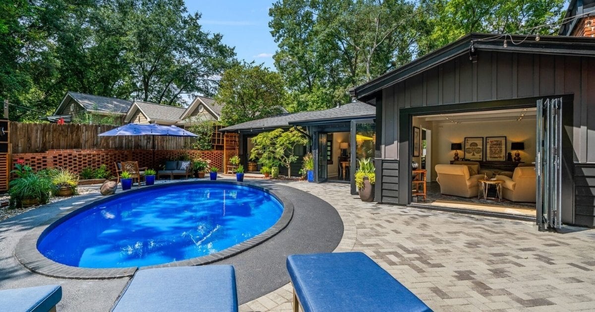 Backyard with swimming pool, paved patio, landscaped seating area, and open indoor-outdoor living space in Atlanta, GA.