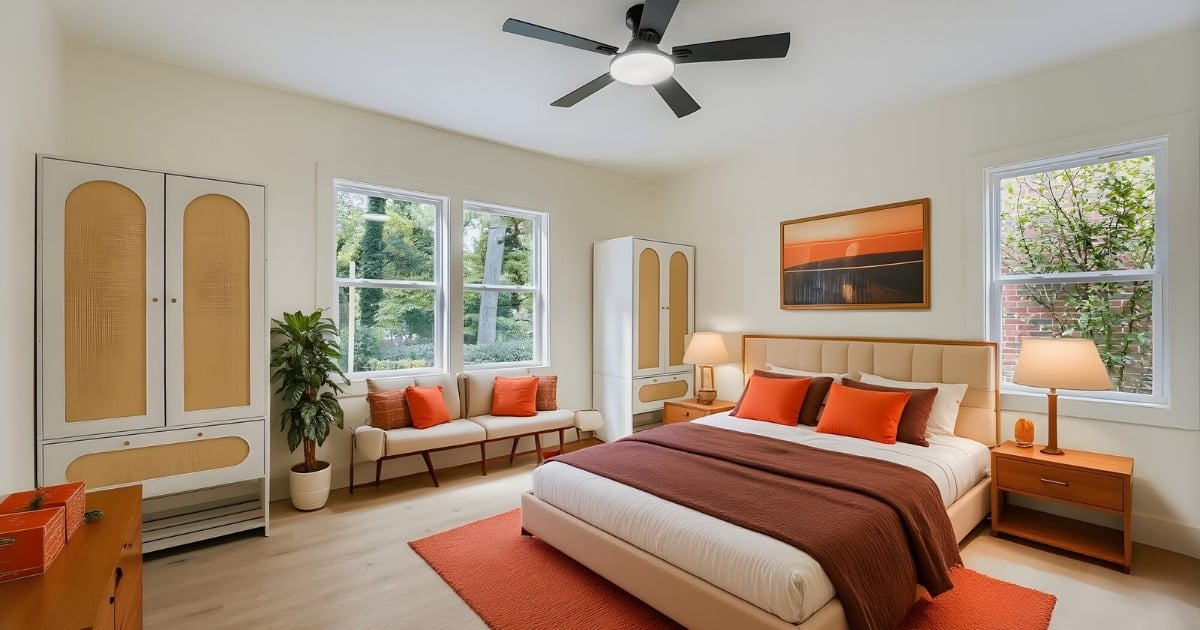 Primary bedroom with warm wood furnishings, orange accents, built-in storage, and large windows in Atlanta, GA.