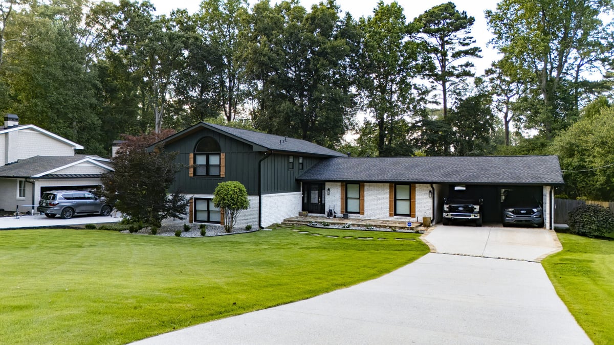 aerial-front-view-two-story-home-dark-green-siding-long-driveway-atlanta-ga-optimized