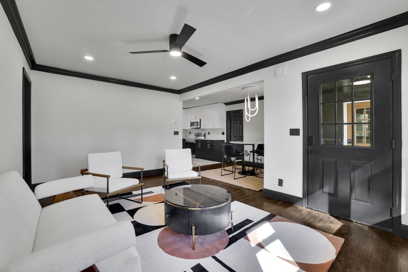 Living room open to the kitchen, with black trim and a black Dutch door