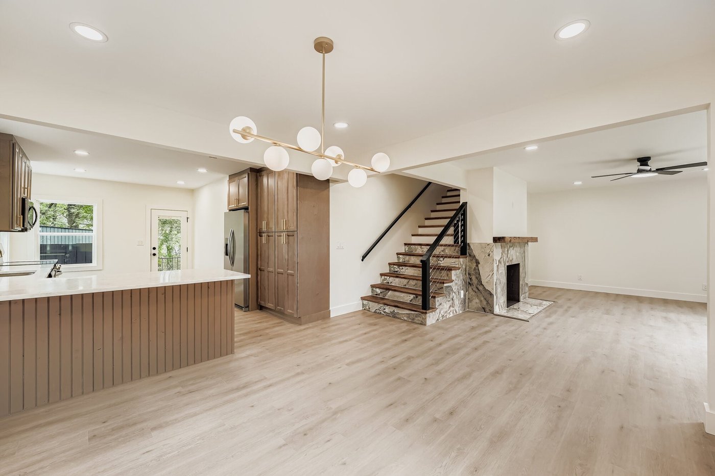Open kitchen and living area with a staircase after a whole home remodel