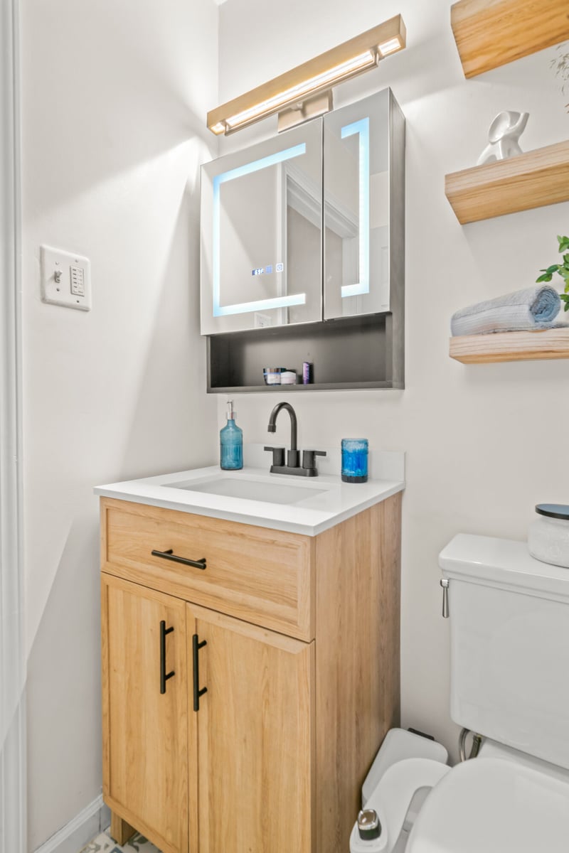 bathroom-vanity-closeup-lighted-mirror-cabinet-toilet-atlanta-ga-optimized