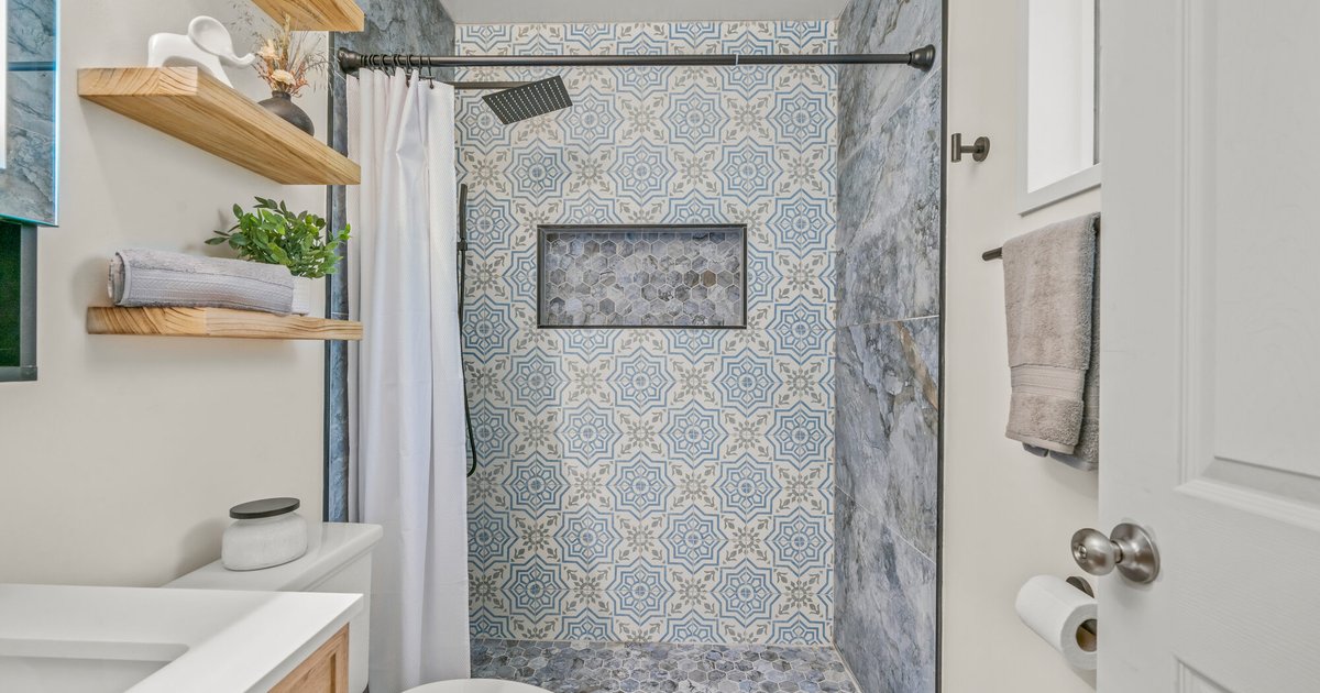 Bathroom remodel with patterned tile shower and natural wood accents in Doraville, GA