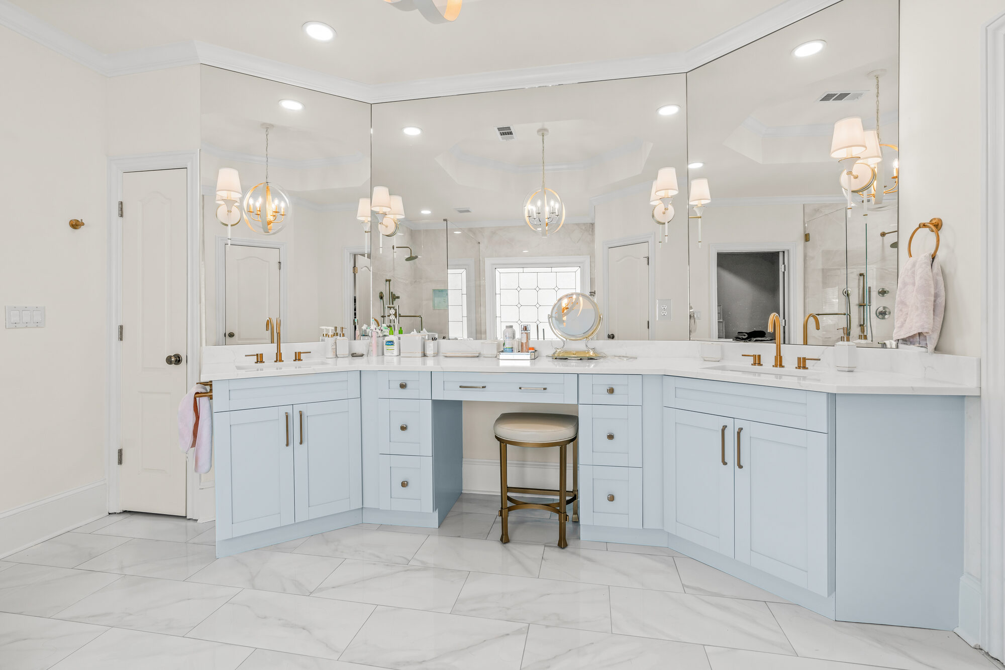 vanity-area-blue-cabinets-marble-counter-chandelier-mirrors-atlanta-ga-optimized